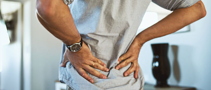 A man holding his lower back in pain